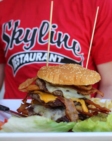 quadzilla burger with bacon cheese and skyline tshirt in background